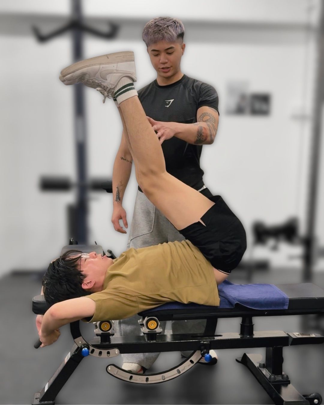 Fred assessing a client's leg raise on a bench.